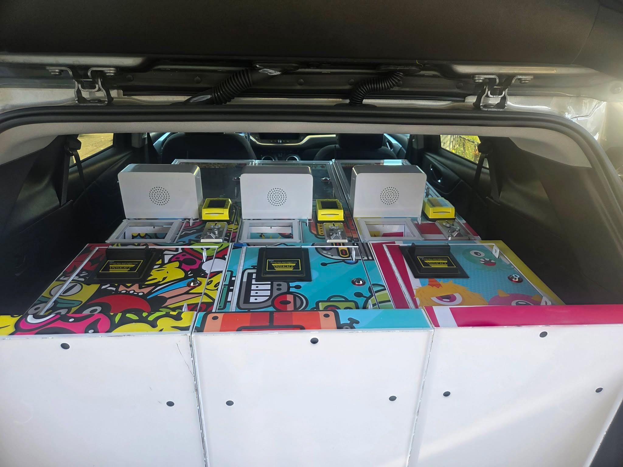 Three claw machines loaded in the back of a car for delivery