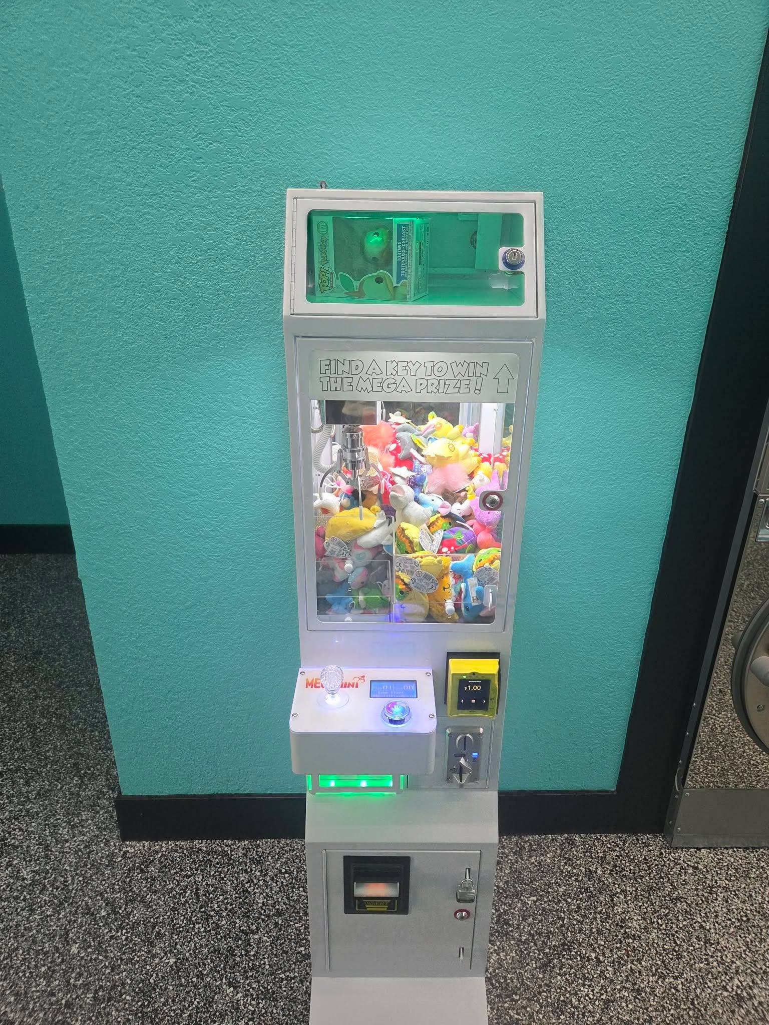 DoBetter claw machine against a teal wall in a laundromat