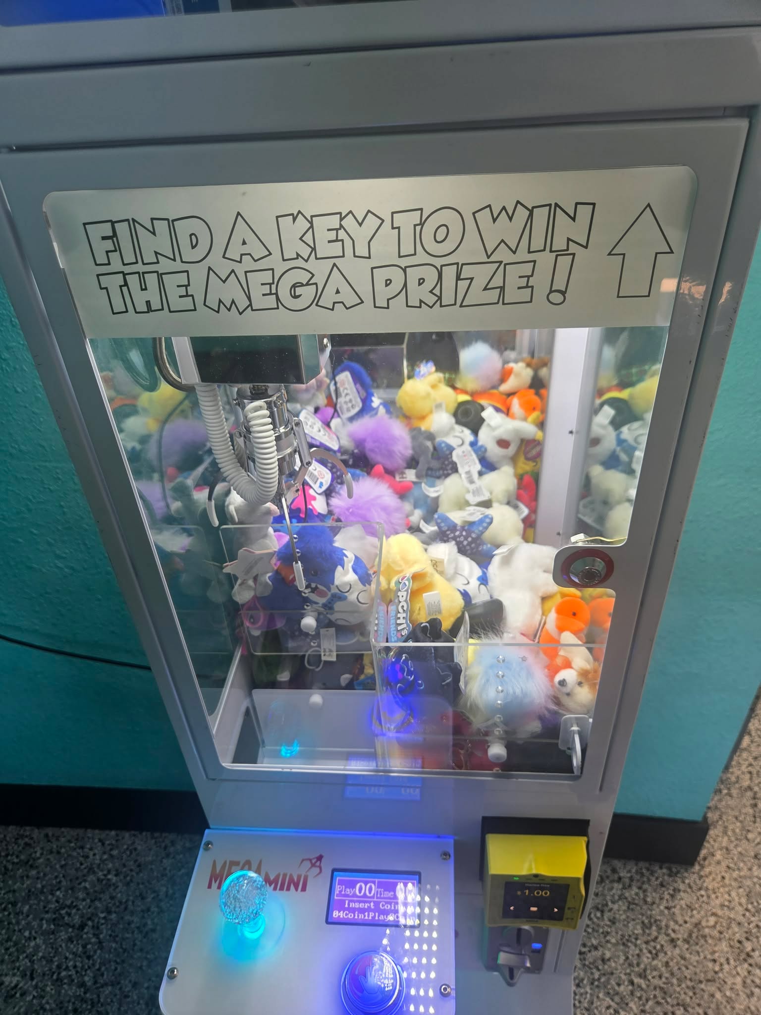 Find a key to win the mega prize sign on a claw machine