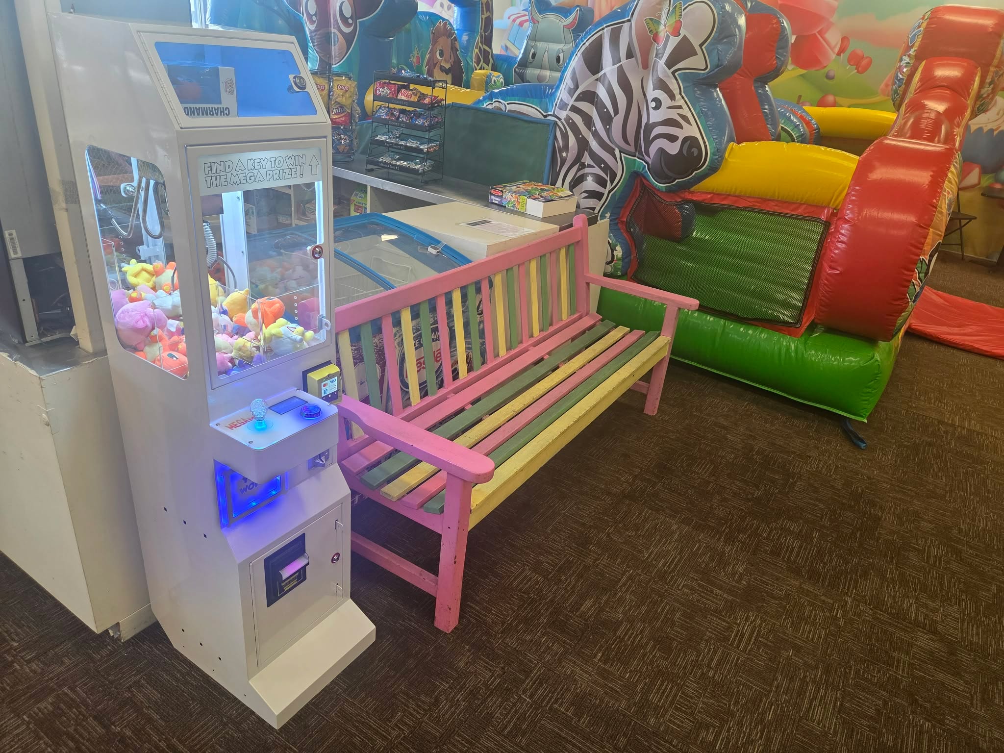 DoBetter claw machine next to a colorful bench at a kids play center